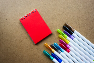 Back to school. The red pages of the notebook. Holiday notes. Colorful markers for children's art. empty paper for painting, space, template. Education, School concept. Kraft backgrounds.