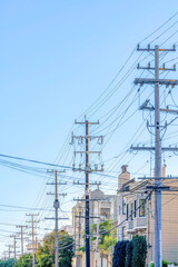 Row of electrical posts with tangled wires in the urban area of San Francisco, California