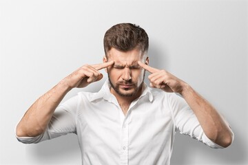 Stressed  man touching his temples and having headache on background
