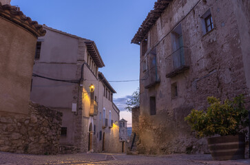 Night falls and the street lamps light up in a street of the medieval village of Alquezar, recognized as one of the most beautiful villages in Spain.