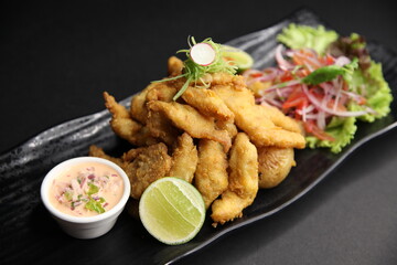 fried fish fingers appetiser with sauce and lemon close up top view