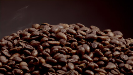 Closeup heap roasted coffee grains on dark backdrop. Coffee beans background.