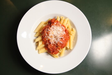 fresh italian pasta penne with tomato sauce top view close up and fork