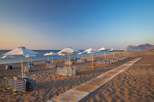 Afandou sea beach with sunshades in Rhodes at sunrise of sunny summer day, Greece, Europe.