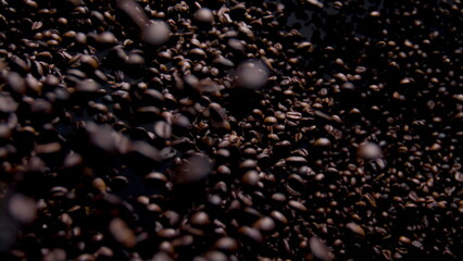 Aromatic coffee grains fly on camera close up. Fragrant brown beans falling.