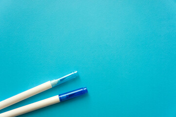 The creative concept of creativity is empty. Two felt-tip pens blue and blue lie off the edge of the blue kraft background. Back to school. Medical Notes. In aquamirin tones. Recipe