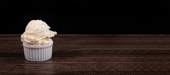 White cream flavored ice cream. Served in a white pot. Gastronomic photography with ample space for texts and arts on the right.