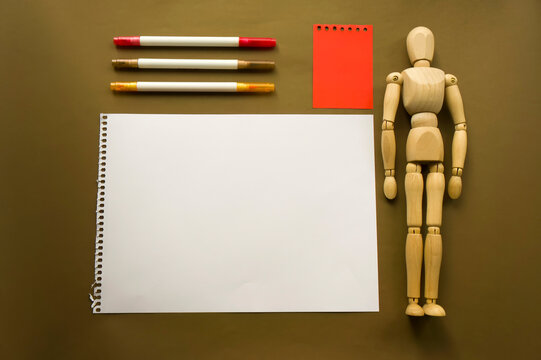 Wooden doll and a blank piece of paper. Wooden mannequin with sheets of paper concept, blank space. Creativity and art. Copyspace