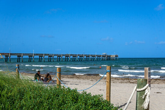 Dania Beach, FL - USA July 27, 2022 Landscape View Of Dania Beach Ocean Park Pier And Swimmers On The Atlantic Ocean  In Southern Florida.