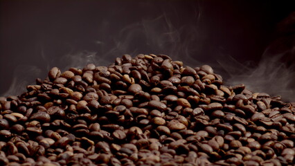 Fragrant smoke coming roasted coffee beans closeup. Steam rising over heap seeds