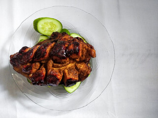 Delicious golden crispy skin whole grilled chicken served with cucumber.