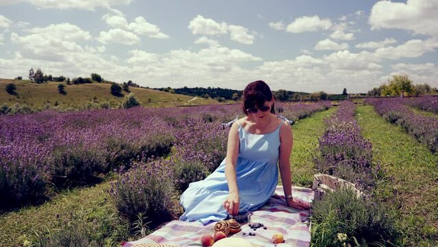 Woman sitting enjoying a summer picnic amongst the lavender