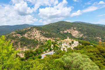 View from the walls of the hilltop medieval castle with the Moulin Saint Roch Gardiole windmill and Grimaud cemetery in view in the hills of Provence Cote d'Azur France.