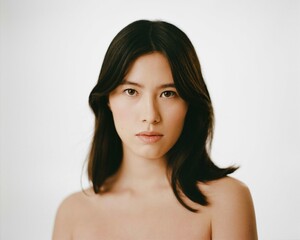 beautiful brunette posing on a white wall