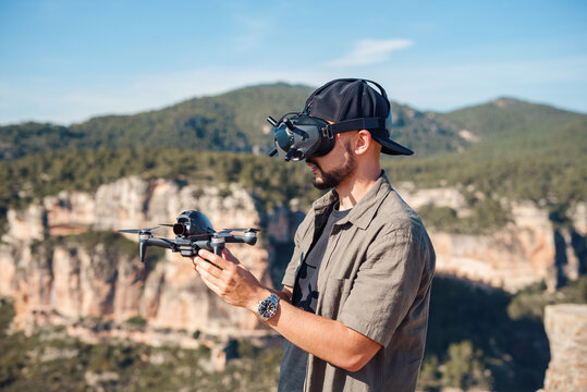 FPV drone operator launching UAV in mountains
