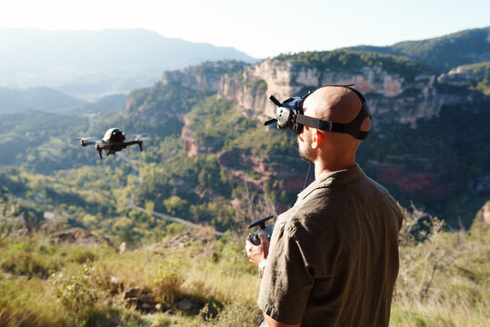 Male operator launching FPV UAV in mountains
