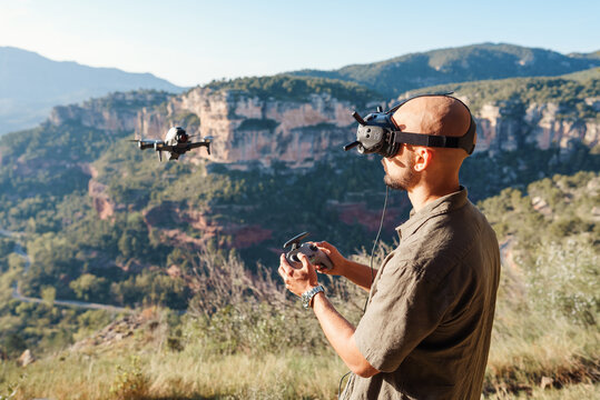 Male traveler controlling drone flight in mountains