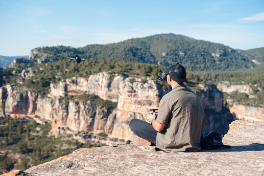 Male operator launching FPV drone in mountainous valley