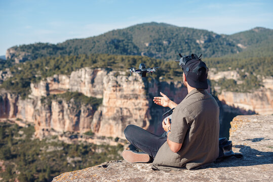 Male launching UAV using controller in highlands