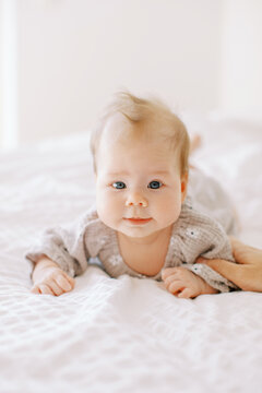 Portrait Of Grey-eyed Baby On Bed