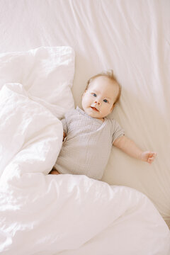 Cute Little Baby On Bed With White Blanket