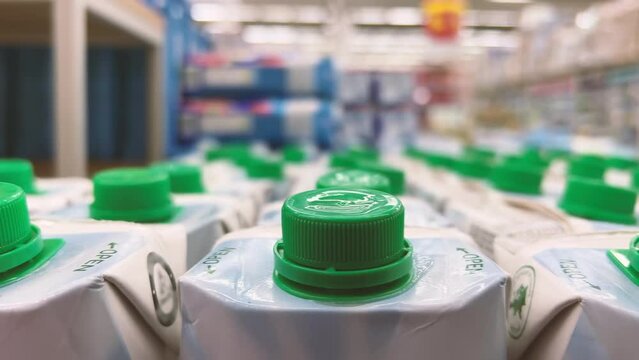 Fruit juice in cartons is on the shelves of a supermarket or grocery store. Close-up