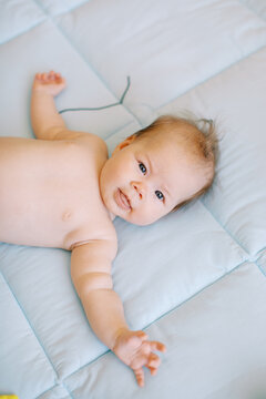 Baby On Bed With Spreaded Arms