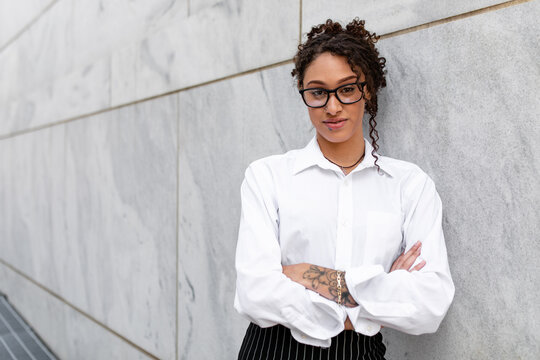 Young Professional Woman Wearing Glasses Looks Intently At The Camera