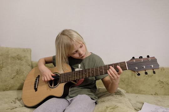  Little girl playing guitar at home