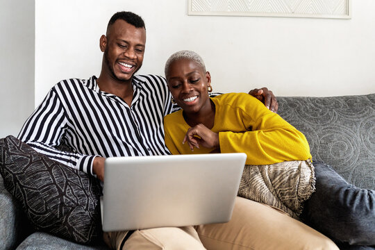 Merry black couple watching video on netbook