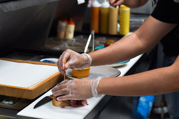 Restaurant kitchen employee working on preparing customer food order