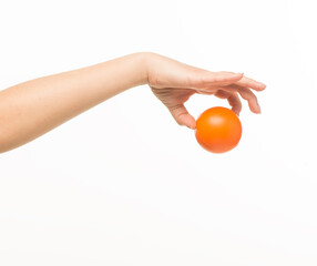 female hands holding an orange sponge ball on a white background isolated