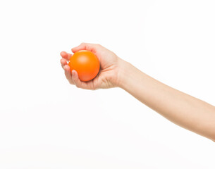 female hands holding an orange sponge ball on a white background isolated