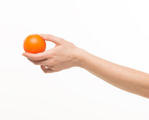 female hands holding an orange sponge ball on a white background isolated