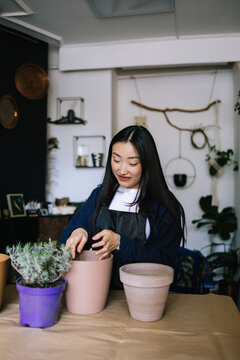 Skilled planter preparing flowerpot with soils and fertilisers in it 