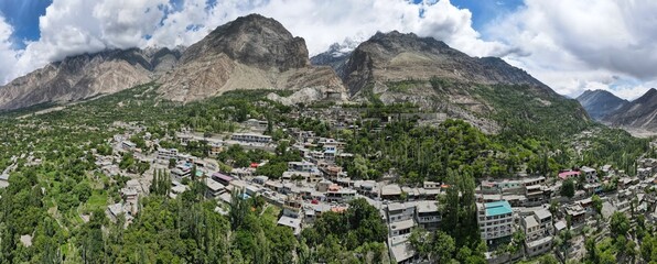 An aerial panorama of Baltit Fort, its surrounding mountains, and Hunza valley during the summer season. 