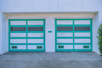 Two sectional garage doors with green trims in San Francisco, California
