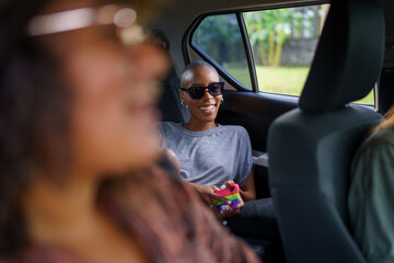 Young black woman chilling in the back of the car with friends
