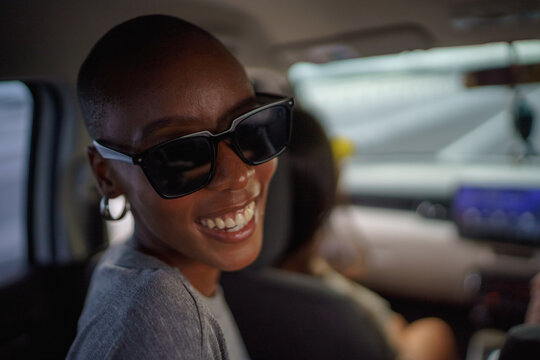 Portrait of young black woman smiling with sunglasses on in car