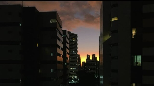Sunset is seen through the city buildings during the winter in the southern hemisphere.