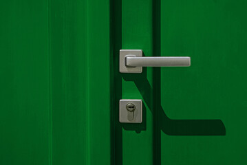 Groen gekleurde deur met handvat en slotclose-up