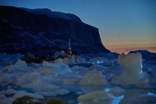 Greenland boats frozen into sea ice, icebergs in winter polar night