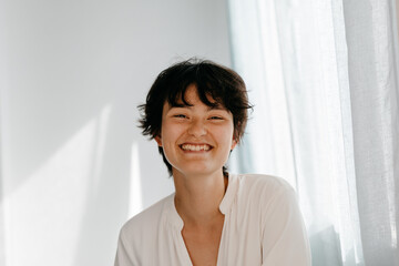 Cheerful non binary person on room