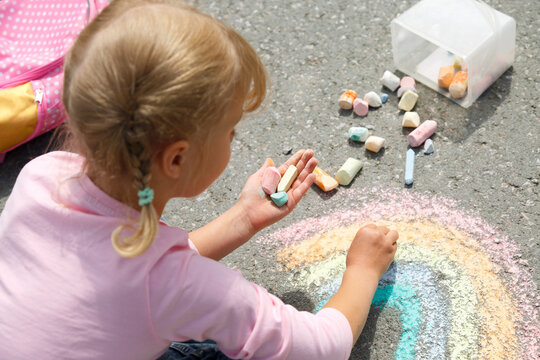 Girl holding chalk and drawing