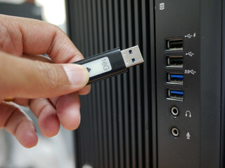 businessman inserting USB thumb drive to computer.	