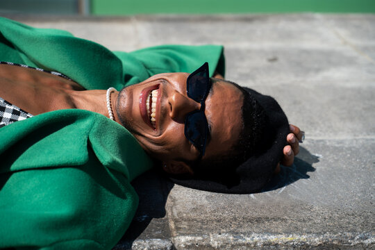 Cool black man enjoying lying on the road at city