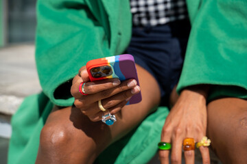 Crop man holding phone with lgtb case