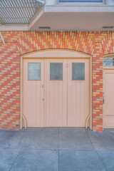 Closed bifold garage door with an arched bricks wall entrance in San Francisco, CA