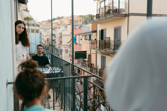 Neighbors talking through the balconies over city street