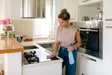 Housewife Cleaning Kitchen Stove With Cloth